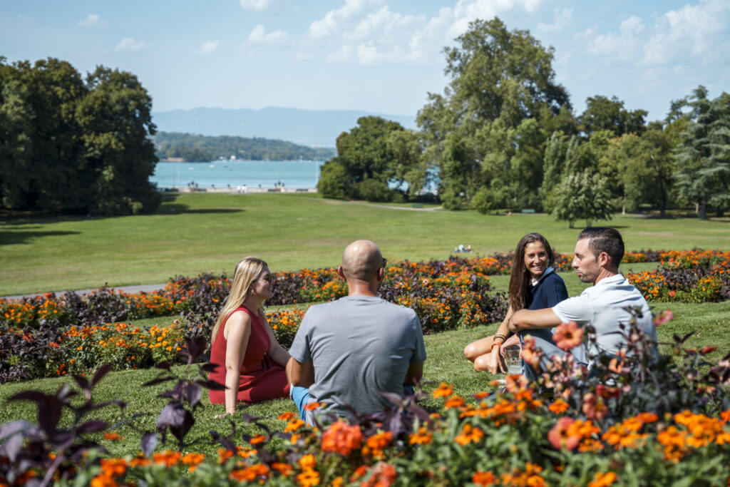 A group of people sitting at tables and a pool of water
Description automatically generated